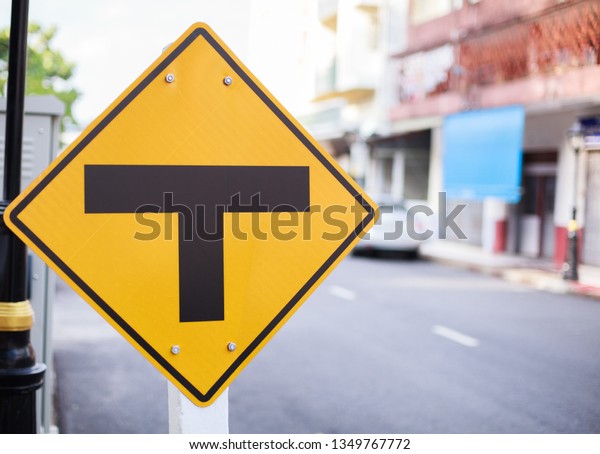 Traffic Sign indicates Intersection, Three way\
Junction. The diamond shape sign with black T junction on yellow\
background, warning that no more road straight ahead, minor road\
turns to major road