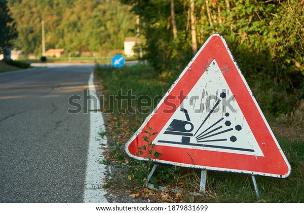 Traffic\
sign red triangle with car depicting possible loose rocks and\
gravel road up ahead                            \
