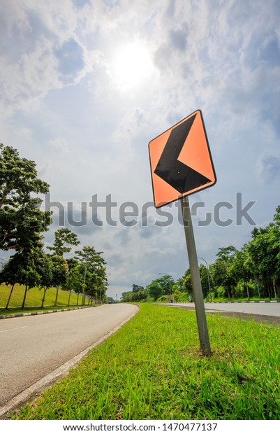 Traffic sign turn left curve and road\
in the forest.Landscape natural way and green pine\
tree