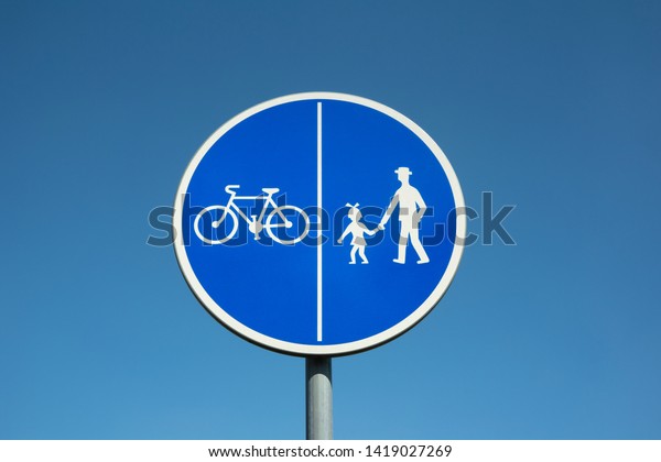 Traffic sign is warning about\
separated and divided lines for bikers doing biking and walkers\
doing walking.  Permission and oder on the road, roadway, pathway\
and way.