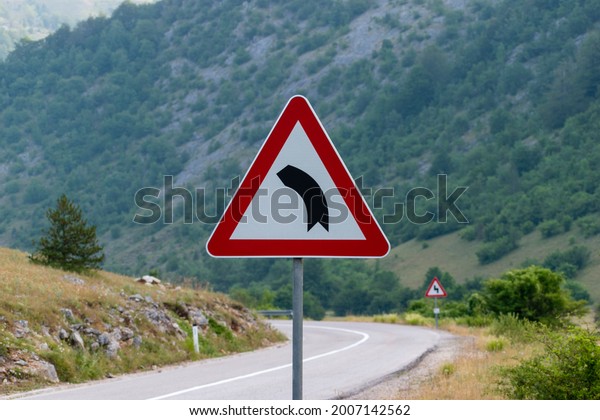 A traffic\
sign warning of a left turn. Traffic that is ahead of the curve,\
Curve signs, traffic signs on the\
road.