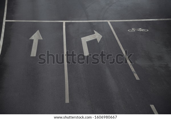 Traffic Signal,road signs\
arrows on asphalted surface,Road sings of straight, right turn\
arrows and bicycle sign on the asphalt road with three our paved\
lanes