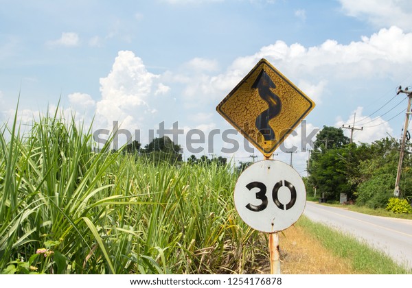 Traffic signs Be careful of roads and curves.\
Drive slowly and be careful of the curves ahead on rural highways\
and beautiful blue\
skies.