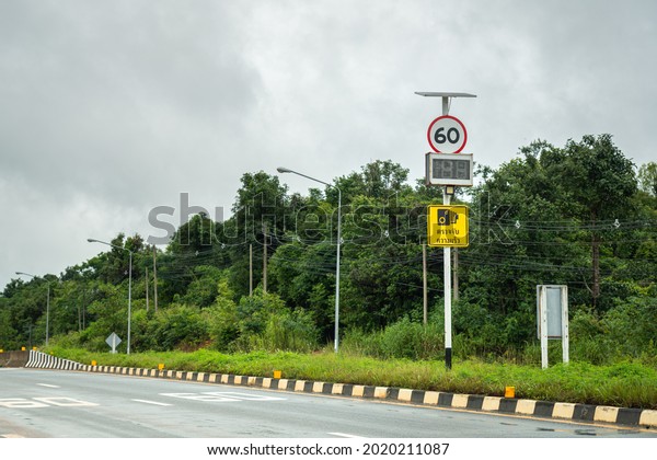 A traffic speed limit warning signpost on rural\
highway during the road is empty (Thai text on the sign is mean\
\