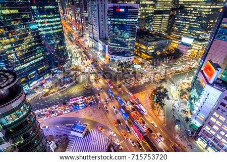 Traffic speeds through an intersection at night in Gangnam, Seoul in South Korea.