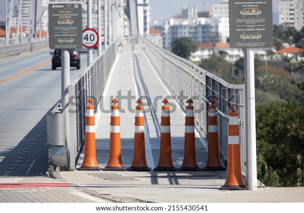 Traffic sticks road signs\
to limit the prohibition of pedestrian traffic on sidewalks and\
roads of white and orange colors in stripes in front of the\
entrance to the bridge