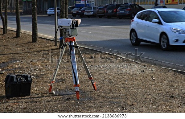 a traffic violation camera\
on a tripod near the dorgi registers speeding crossing a solid\
line