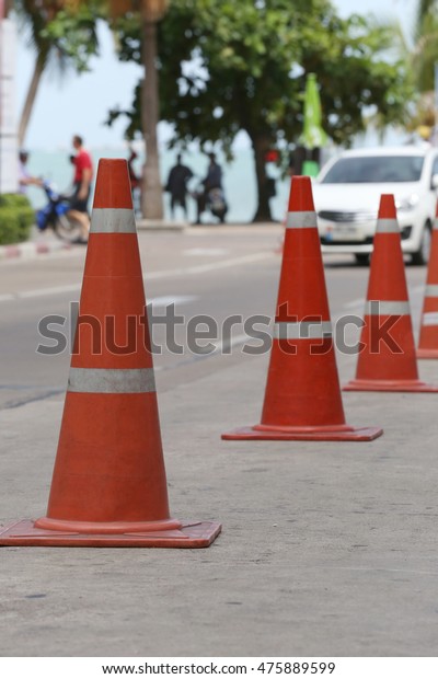 traffic warning cone in row to separate\
route in walkway for\
pedestrians.