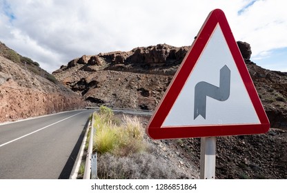 Traffic Warning sign: Bend in Road. A triangular street sign giving notice of a bend ahead in the highway. - Powered by Shutterstock