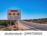 Traffic warning sign: caution, stray animals. With an image of an echidna, an emu and a kangaroo, along a highway in the outback of Western Australia
