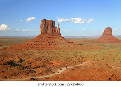 Traffic Winding Through Monument Valley with Left and Right Mitten Rock Formations in the "Background - Arizona