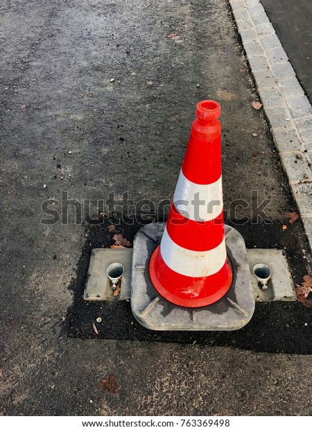 Trafficked safety\
cone on building site on\
asphalt