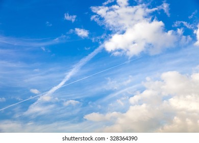 The trail of the aircraft in blue cloudy sky