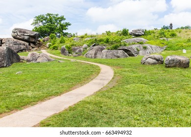 Trail leading to Devil's Den in Gettysburg battlefield national park with rock boulders during summer