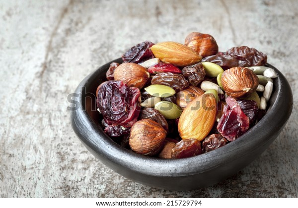 Trail mix in black bowl.  Delicious healthy fruit,\
nuts and seeds.