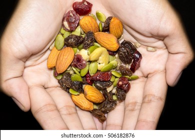 Trail Mix On The Hand In Black Background.