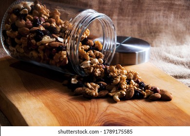 Trail Mix In An Overturned Glass Jar Over A Wooden Table 