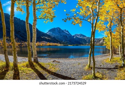 The trail to the mountain lake.  Autumn trees at mountain lake. Mountain lake view. Lake in autumn mountains