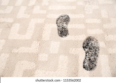 Trail Of Muddy Footprints On Beige Carpet