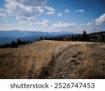 Trail on grassy mountain top in Bridger Mountain range by Bozeman Montana in summer