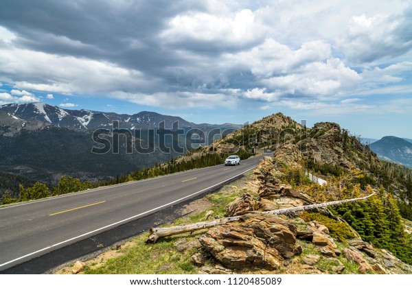 Trail Ridge Road - A stormy Spring\
day view of a narrow section of Trail Ridge Road winding at top of\
mountains. Rocky Mountain National Park, Colorado, USA.\
