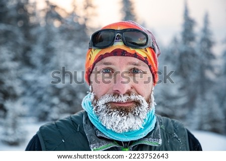 trail runner with frozen beard training in winter landscape