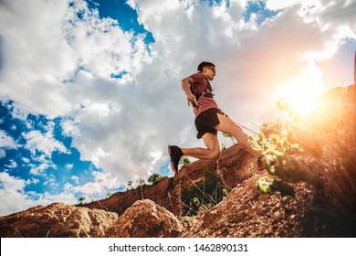 Trail Runner Jumping On The Horizon And Stone