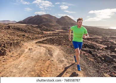 Trail runner male athlete running in nature rocky volcanic mountain background. Active fit sports man in compression sportswear sprinting on rocks path working out cardio training body. - Shutterstock ID 768558787