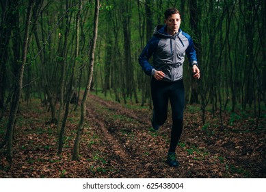 Trail Runner Man Training In The Rainy Mud Forest