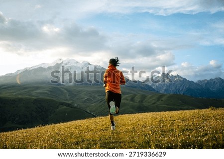 Trail runner running on the high altitude grassland mountain top