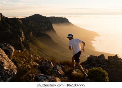 A Trail Running Running Along A Challenging Mountain Trail At Sunset In The Mountains Of Cape Town.