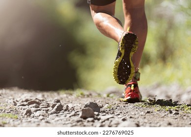 Trail running athlete exercising for fitness and health outdoors on mountain pathway, closeup of running shoes in action. Soaked running shoes - Powered by Shutterstock