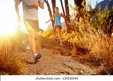 Trail running marathon athlete outdoors sunrise couple training for fitness and healthy lifestyle