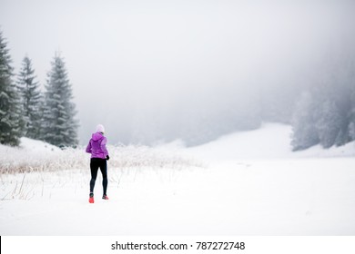 Trail Running Woman In Winter Mountains. Sport, Fitness Inspiration And Motivation. Young Happy Woman Cross Country Running In Mountains On Snow, Winter Day. Female Trail Runner Jogging Outdoors.