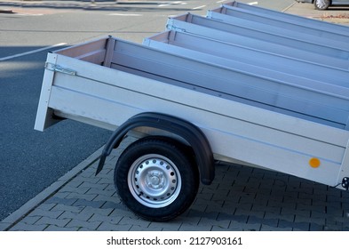 trailer behind a car in the parking lot at the rental shop. just harness to the ball of the towing device. homologation and technical inspections. metal side panels