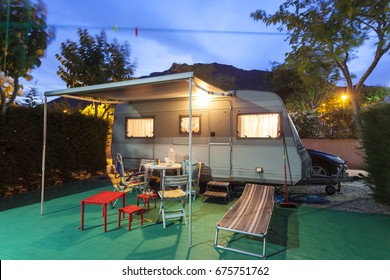 Trailer Caravan On A Camping Site Illuminated At Night