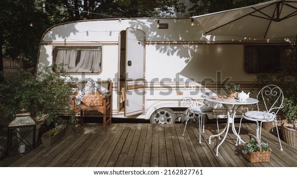 Trailer\
exterior with nobody, camper van at nature. Summer park with rv\
car, campsite outdoor design with cozy decoration. Camping at motor\
home concept, outside furniture near\
vehicle.