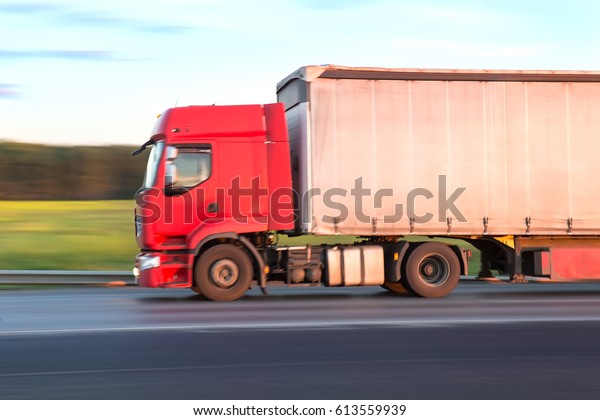 trailer
with red cabin moves at high speed on 
highway