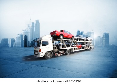 The trailer transports cars on highway with big city background