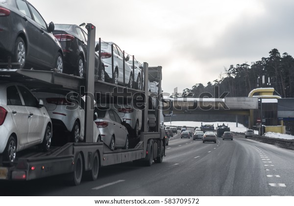 The trailer transports\
cars on highway