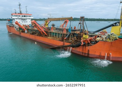Trailing suction hopper dredger operating at sea during maritime construction project in Indonesia