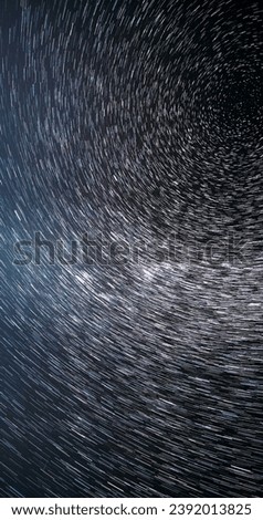 Trails Of Stars. Bewitching Illusion Of Star Trails. Spin Of Unusual Amazing Stars Effect In Sky. Meteors Cross Dark Blue Sky. Rotate Of Sky Background. Large Exposure. Star And Meteoric Trails On