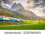 Train in Bavarian alps at autumn and wooden barns at sunset, Garmisch, Germany