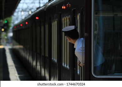 The train conductor watching at the platform.