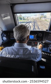 a train driver inside the driver's cabin driving a regional train
