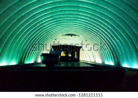 Train driving through a circular blue tunnel with train silhouette visible and back of drive . Shot in Kankaria lake Ahmedabad Gujarat india asia