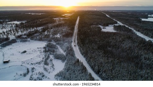 Train in finnish winter, aerial drone shot of a cargo locomotive, in a snowy forest, in arctic wilderness, sunset, in Scandinavia
