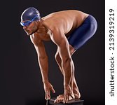 Train insane or remain the same. Studio shot of a handsome swimmer ready to dive off the starting block.