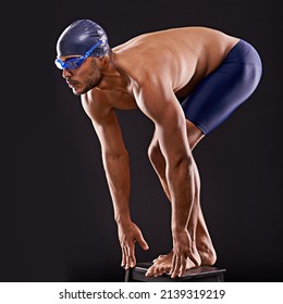 Train insane or remain the same. Studio shot of a handsome swimmer ready to dive off the starting block. - Powered by Shutterstock