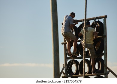 Train like theres no finish line. Shot of men climbing over an obstacle at bootcamp. - Powered by Shutterstock